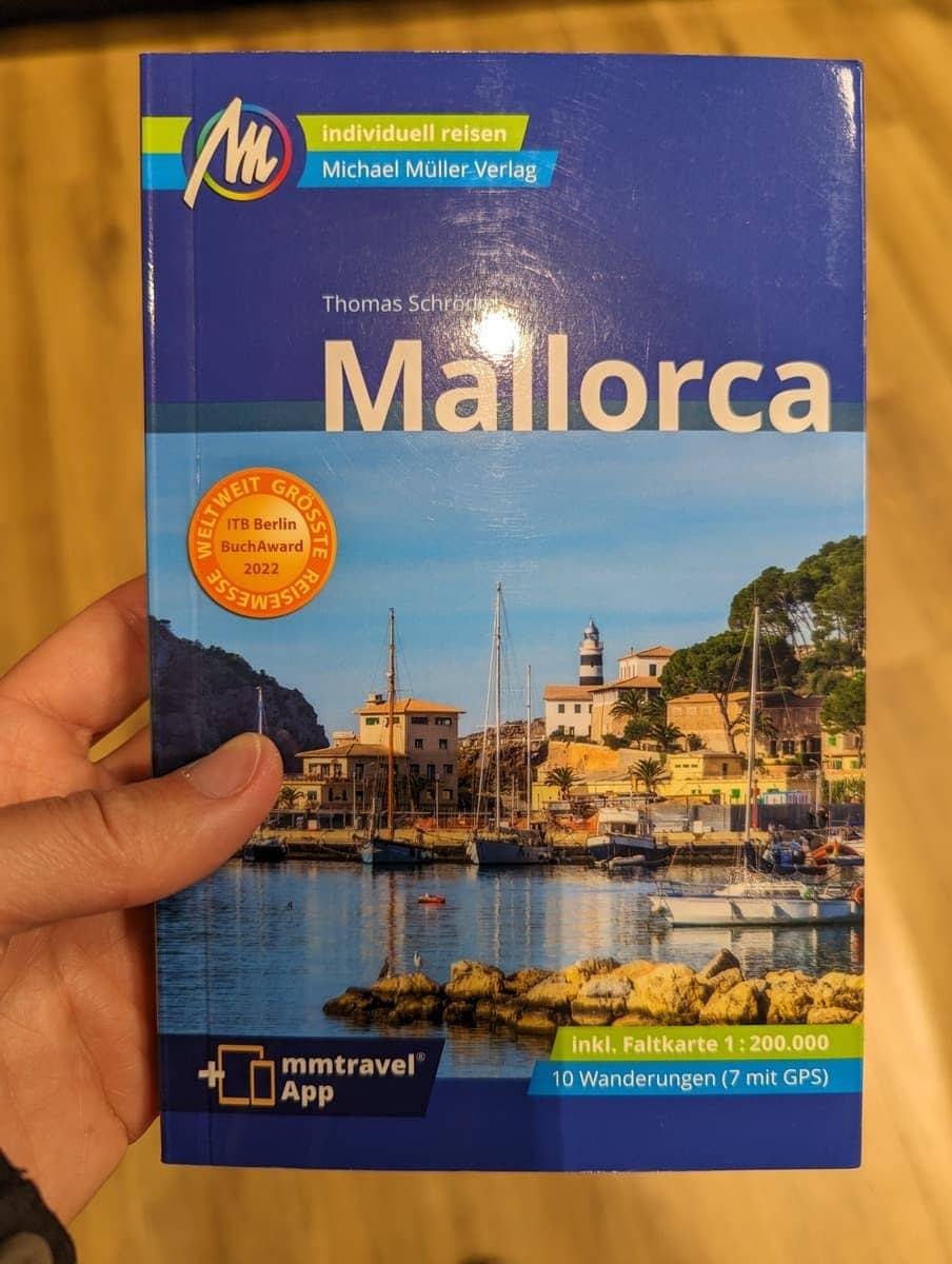 Linda hält den Reiseführer von Mallorca in der Hand