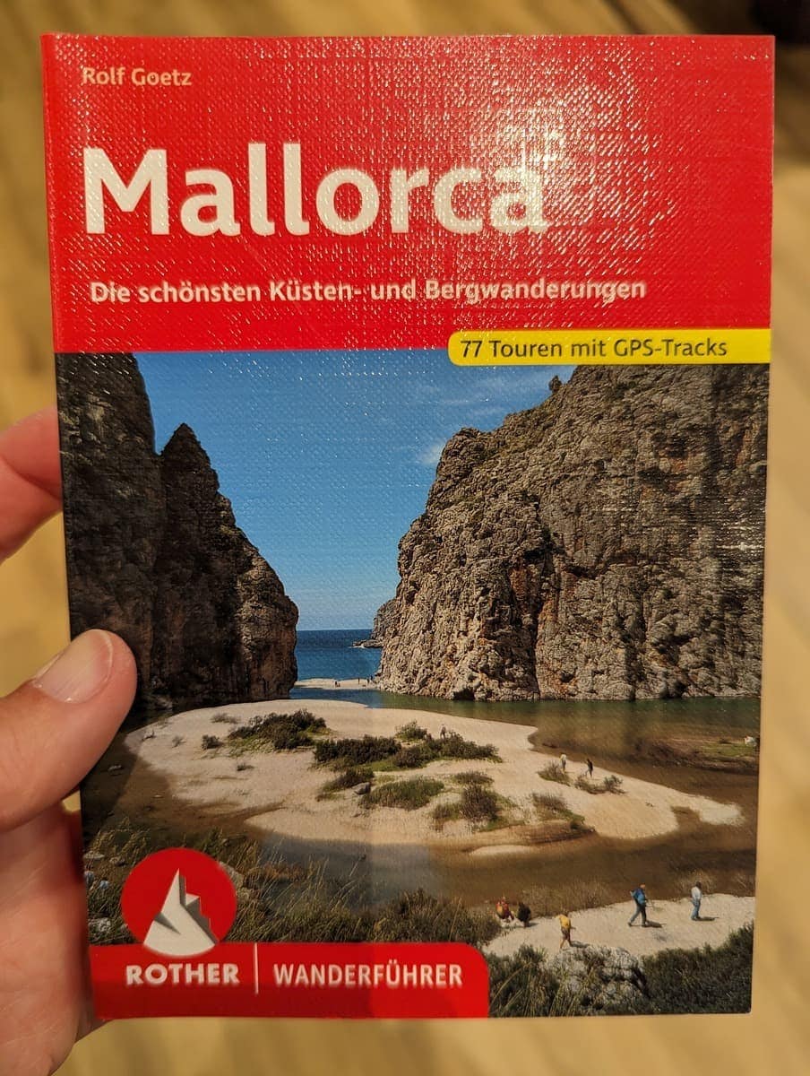 Linda hält den Rother Wanderführerführer Mallorca in der Hand